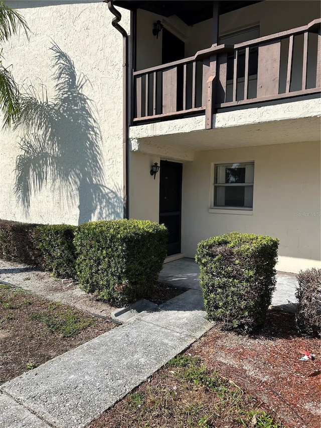 view of exterior entry with a balcony