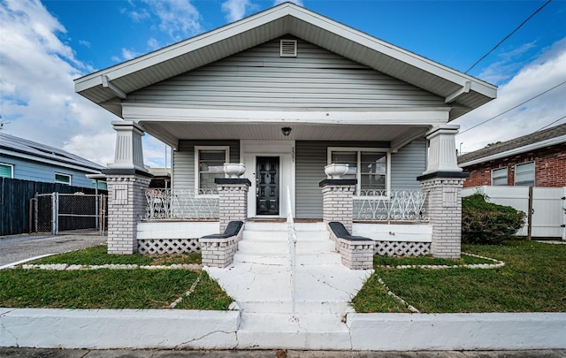 bungalow-style house with covered porch and a front yard