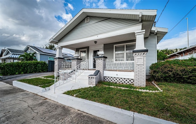 view of front of house with a porch and a front yard