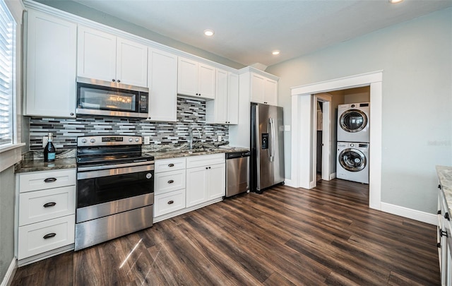 kitchen featuring stacked washing maching and dryer, white cabinets, stainless steel appliances, and dark wood-type flooring