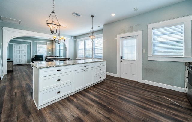 kitchen featuring dark hardwood / wood-style flooring, white cabinetry, a healthy amount of sunlight, and pendant lighting