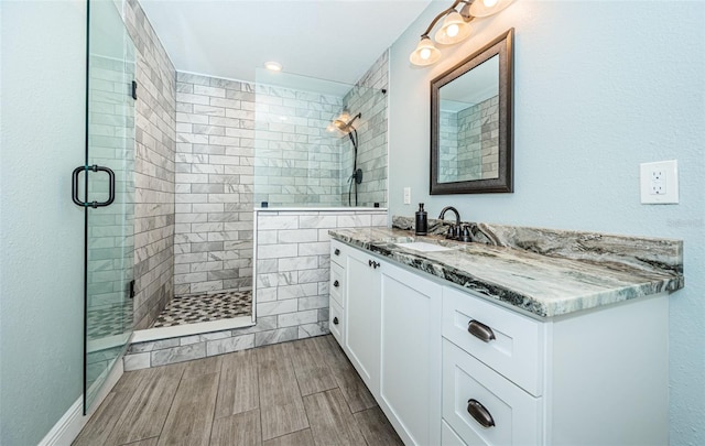 bathroom featuring vanity and a shower with shower door