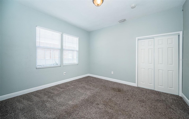 unfurnished bedroom with a closet and carpet flooring