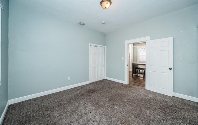 unfurnished bedroom featuring a closet and dark colored carpet