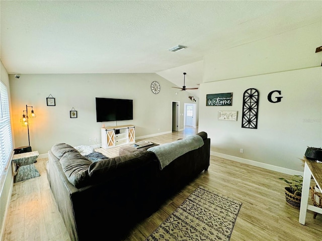 living room featuring hardwood / wood-style flooring, ceiling fan, and vaulted ceiling