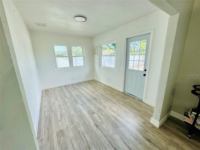 interior space with light hardwood / wood-style floors and a textured ceiling