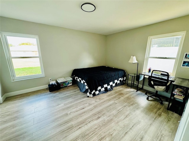 bedroom featuring light hardwood / wood-style floors and multiple windows