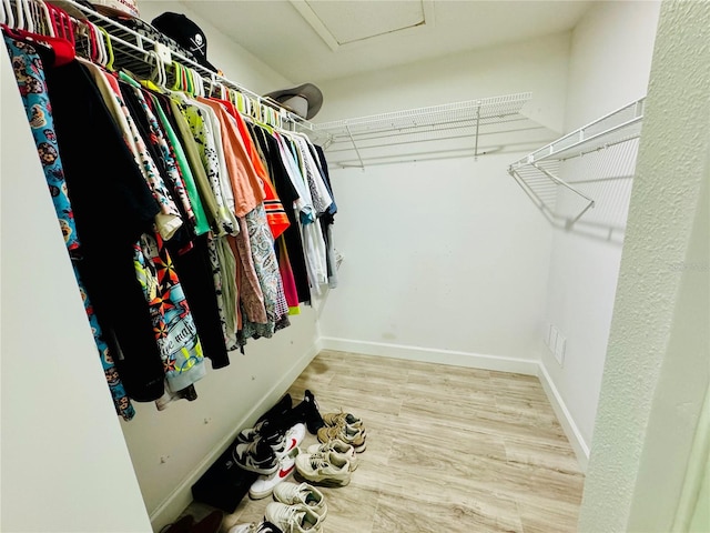 walk in closet with hardwood / wood-style floors