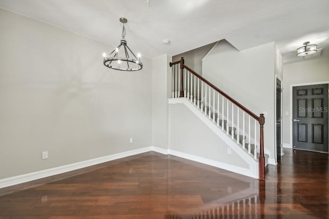 foyer featuring dark wood-type flooring and an inviting chandelier