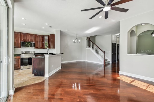 kitchen with appliances with stainless steel finishes, sink, pendant lighting, and dark hardwood / wood-style floors