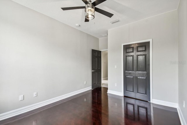 empty room featuring dark hardwood / wood-style flooring and ceiling fan