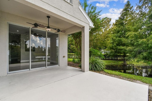 view of patio featuring a water view and ceiling fan