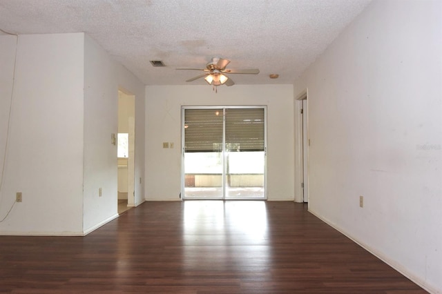 unfurnished room with a textured ceiling, dark wood-type flooring, and ceiling fan