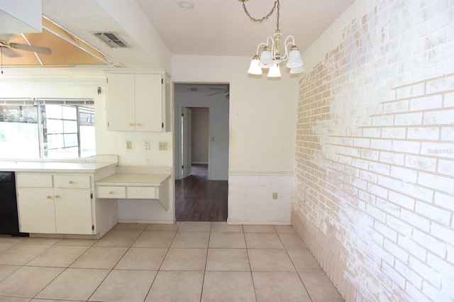 kitchen featuring white cabinetry, brick wall, light tile patterned flooring, and hanging light fixtures