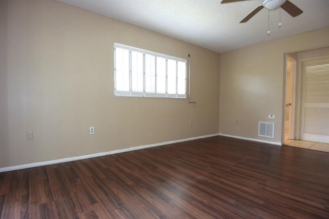 empty room with dark hardwood / wood-style floors, a textured ceiling, and ceiling fan