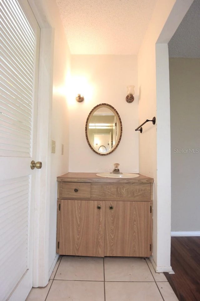 bathroom featuring vanity, a textured ceiling, and tile patterned flooring