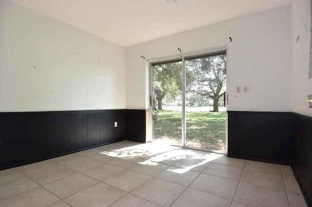 tiled empty room with a textured ceiling