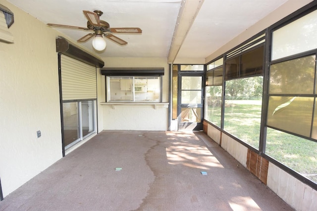 unfurnished sunroom with ceiling fan