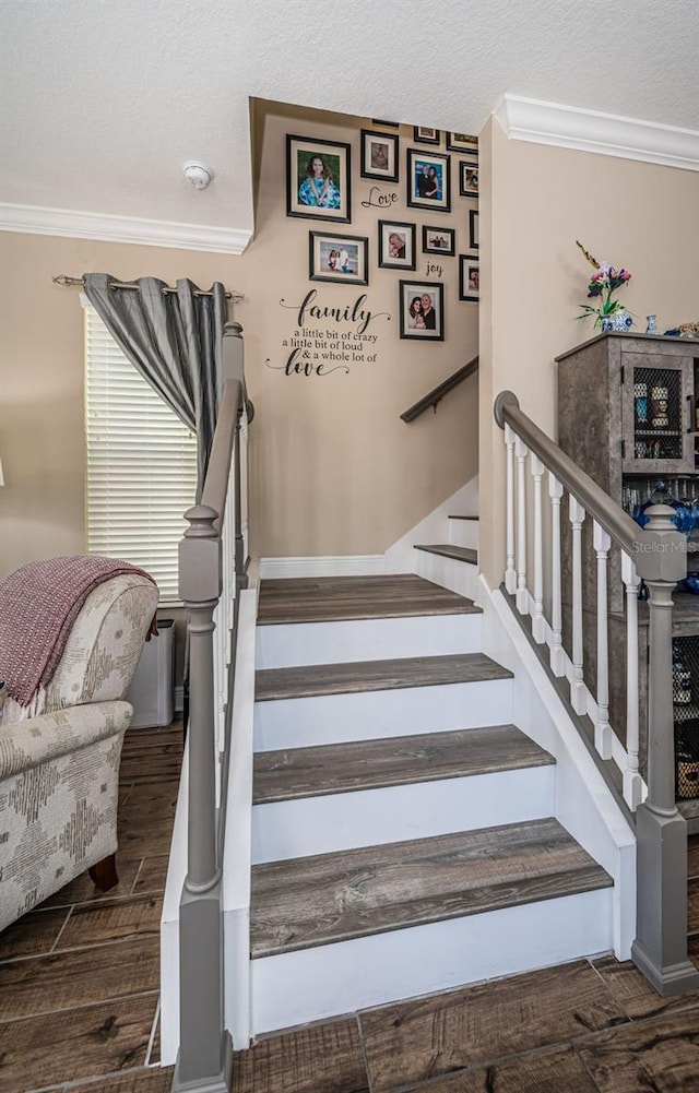 staircase featuring ornamental molding, a textured ceiling, and hardwood / wood-style floors