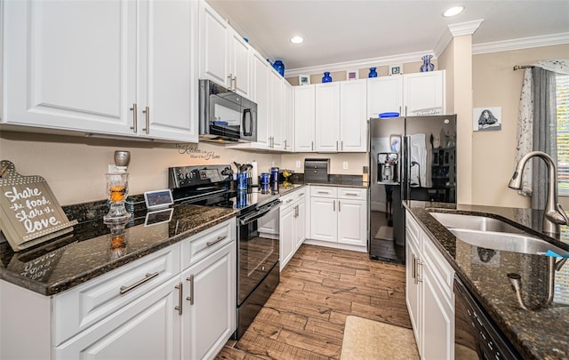 kitchen featuring black appliances, sink, white cabinetry, light hardwood / wood-style floors, and ornamental molding