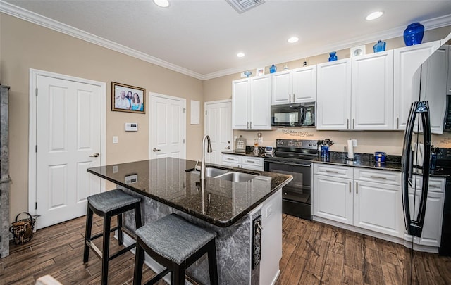 kitchen featuring an island with sink, sink, black appliances, white cabinets, and dark hardwood / wood-style flooring