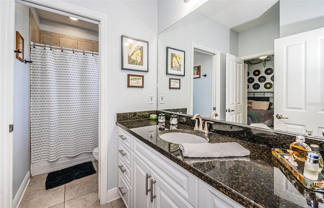 bathroom with vanity, a shower with curtain, toilet, and tile patterned floors