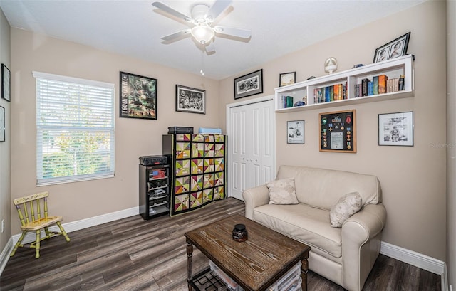 living area featuring ceiling fan and dark hardwood / wood-style flooring