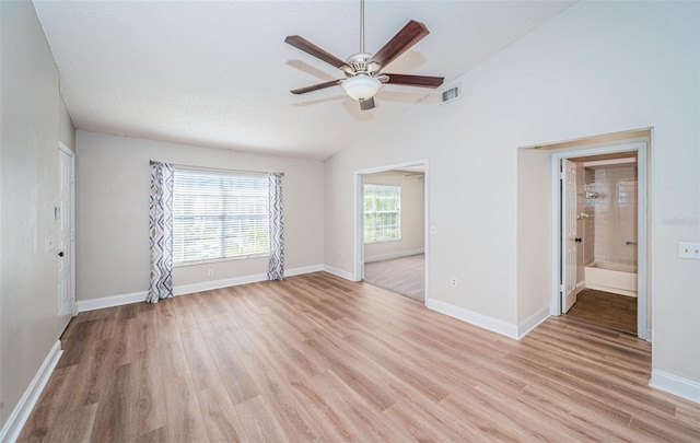 unfurnished room with light hardwood / wood-style flooring, a textured ceiling, lofted ceiling, and ceiling fan