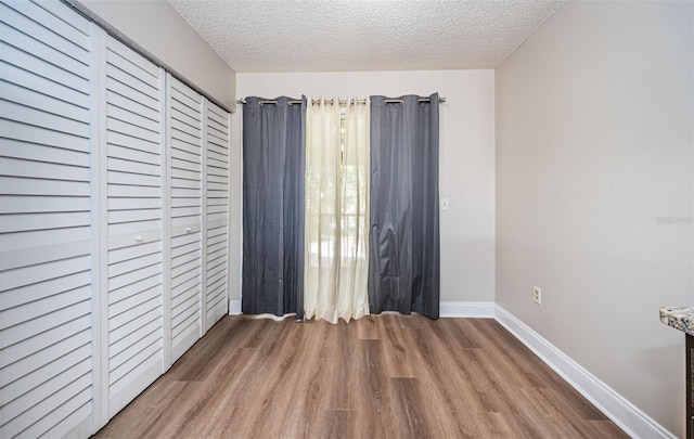 unfurnished bedroom with a textured ceiling and hardwood / wood-style floors