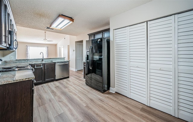 kitchen featuring a textured ceiling, stainless steel appliances, and light hardwood / wood-style floors