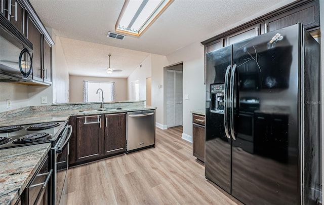 kitchen featuring light hardwood / wood-style floors, dark brown cabinetry, black appliances, and sink