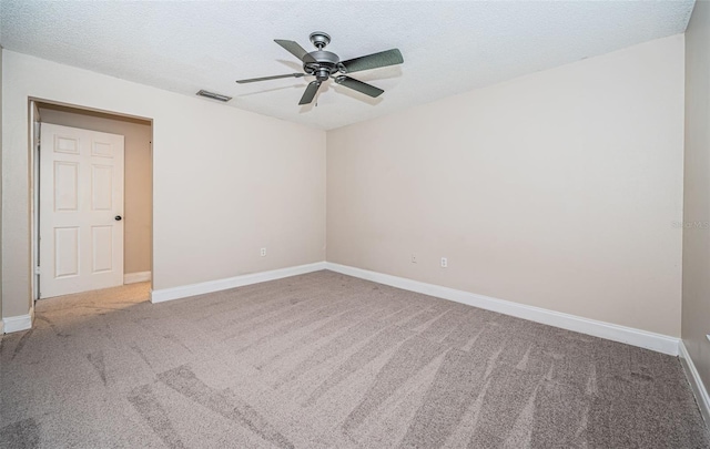 spare room featuring ceiling fan, carpet, and a textured ceiling