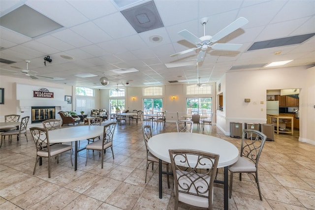 dining space featuring ceiling fan, light tile patterned flooring, and a paneled ceiling