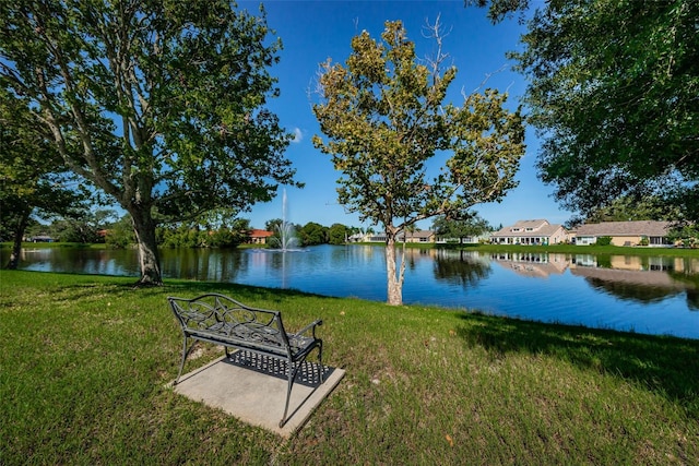 view of community featuring a lawn and a water view