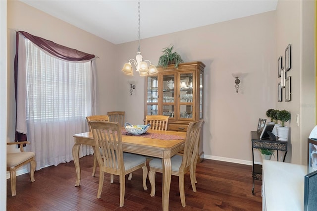 dining area featuring dark hardwood / wood-style floors and an inviting chandelier