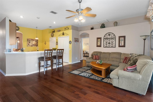 living room featuring dark wood-type flooring and ceiling fan