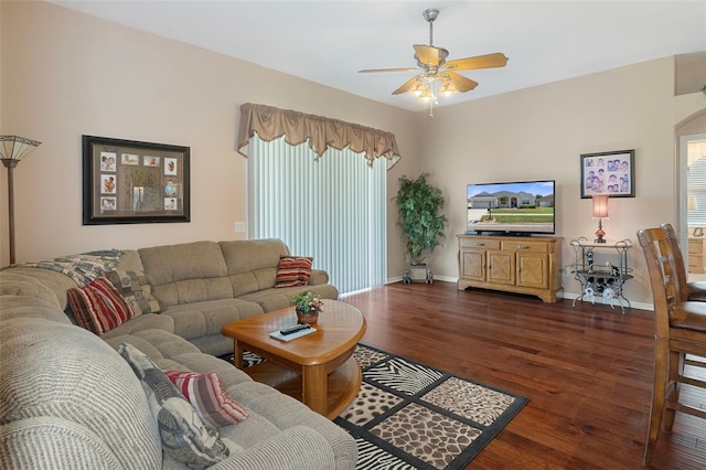 living room with dark wood-type flooring and ceiling fan