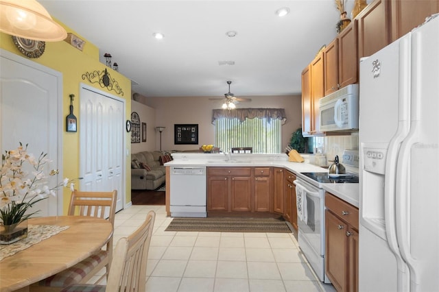 kitchen featuring kitchen peninsula, sink, light tile patterned flooring, white appliances, and ceiling fan