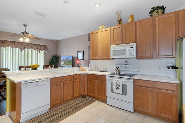 kitchen with kitchen peninsula, ceiling fan, light tile patterned floors, sink, and white appliances