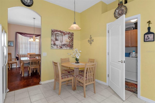 dining space featuring an inviting chandelier, washer / clothes dryer, and light wood-type flooring