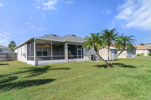 back of property with a lawn and a sunroom