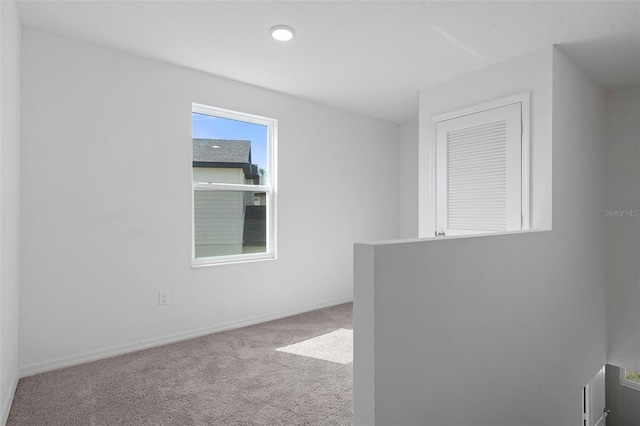 unfurnished room featuring light colored carpet