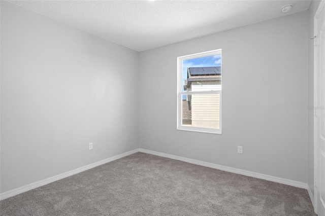 carpeted spare room with a textured ceiling