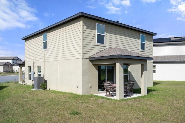 rear view of property featuring a patio area, a yard, and cooling unit