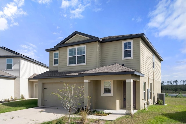 view of front of home with central AC, a garage, and a front lawn