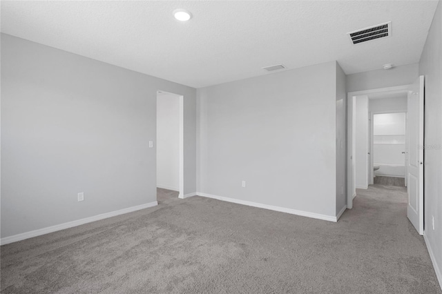 empty room featuring light colored carpet and a textured ceiling