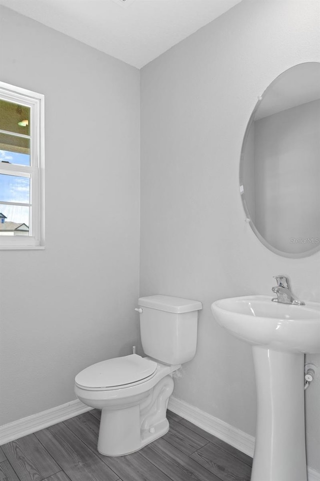 bathroom featuring toilet, wood-type flooring, and sink