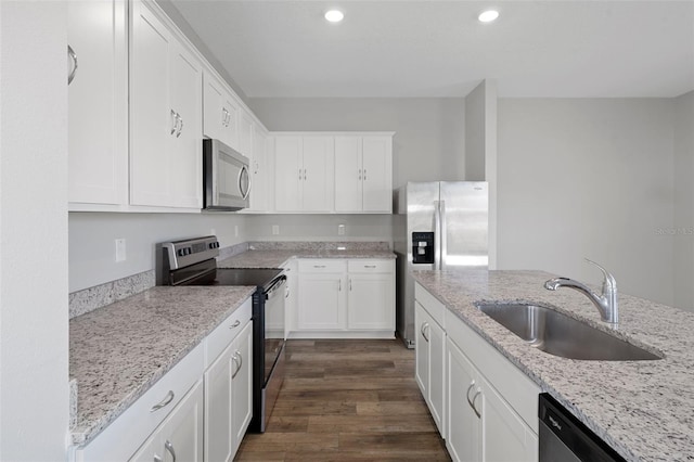 kitchen with white cabinets, sink, dark hardwood / wood-style floors, appliances with stainless steel finishes, and light stone counters