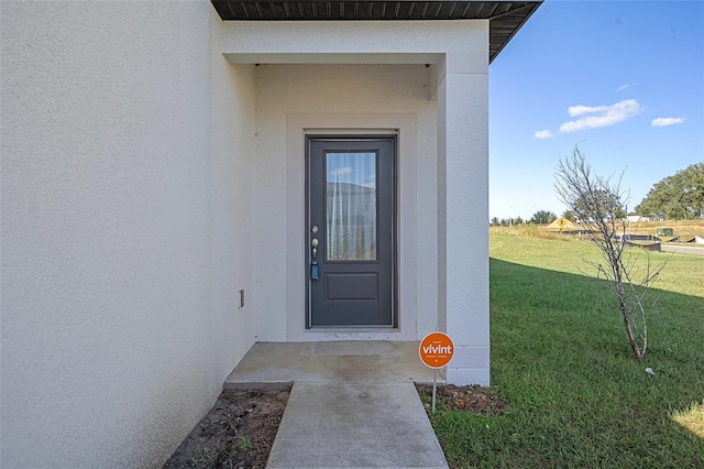 doorway to property with a yard