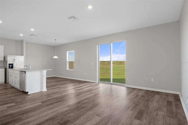 unfurnished living room with dark hardwood / wood-style floors and sink